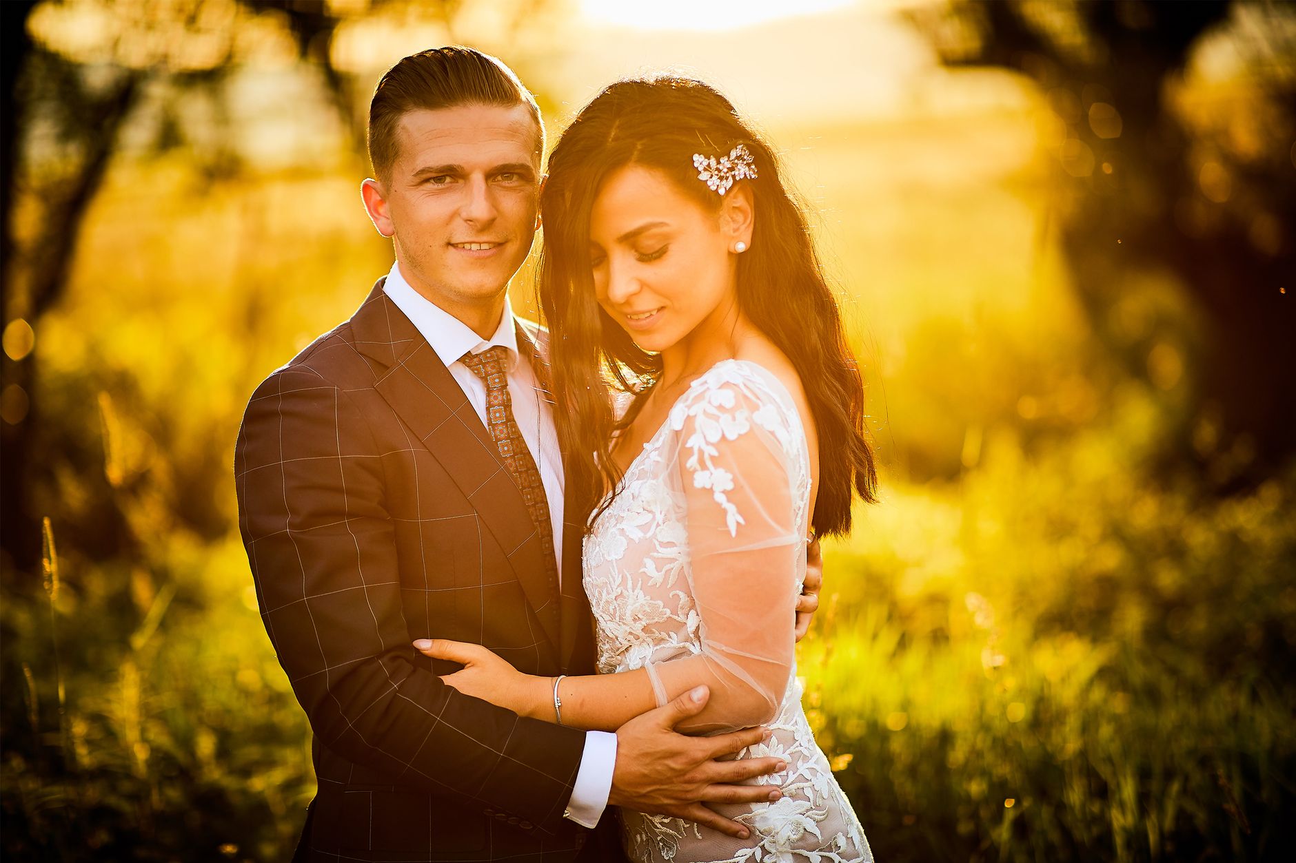 A couple beneath the live oaks at golden hour